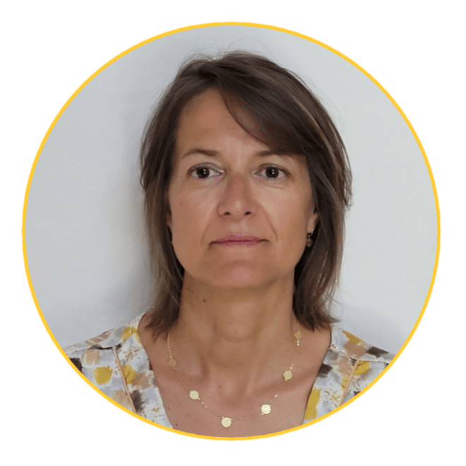 Photo de Frédérique Capelle, consultante juriste en marchés publics. Portrait professionnel avec un fond neutre, vêtue d'une blouse à motifs discrets et d'un collier doré, incarnant expertise et professionnalisme.